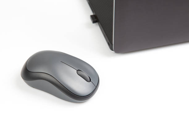 istock Computer wireless mouse next to a laptop on a white table close-up. electronic personal industry 1413637070