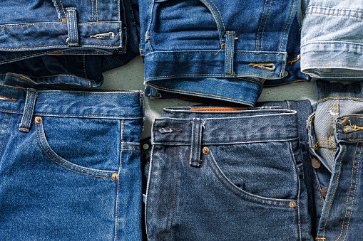 vista superior de jeans doblados, Jeans azules en una pila de jeans. Vista superior de varias telas de mezclilla sobre fondo blanco. Varios vaqueros largos photo