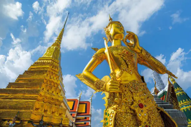 Photo of Statue of gods in Wat Phra Kaew, Thailand,Kinnaree statue at Golden pagoda at Temple of the Emerald Buddha. Wat Phra Kaew and Grand palace in old town, urban city. Buddhist temple, Thai architecture.