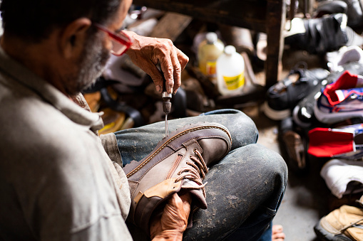 Yolombo, Antioquia - Colombia. July 24, 2022. The person whose trade is the manufacture and repair of footwear is called a shoemaker.