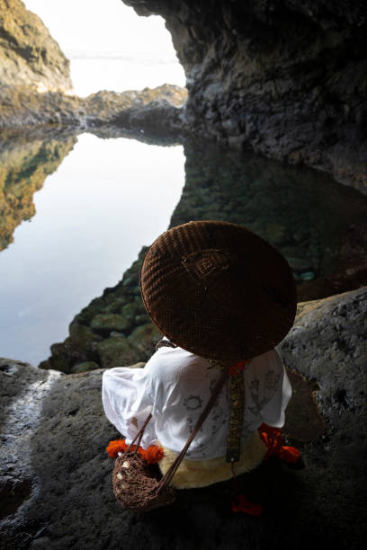 Shugendo monk is sitting in cave and meditating while looking at open sea