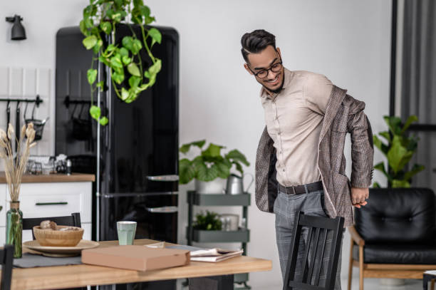 Man taking off his jacket standing in apartment stock photo