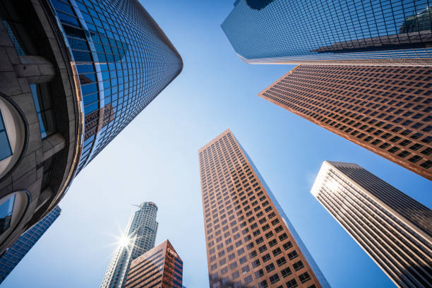 A low angle view of tall modern skyscrapers reaching up towards a clear sky in LA's modern downtown financial district.
