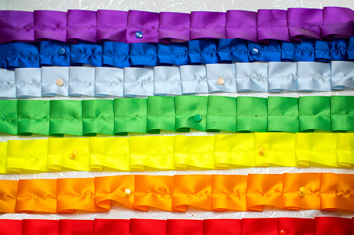 Rainbow of folded nailed or pinned ribbons