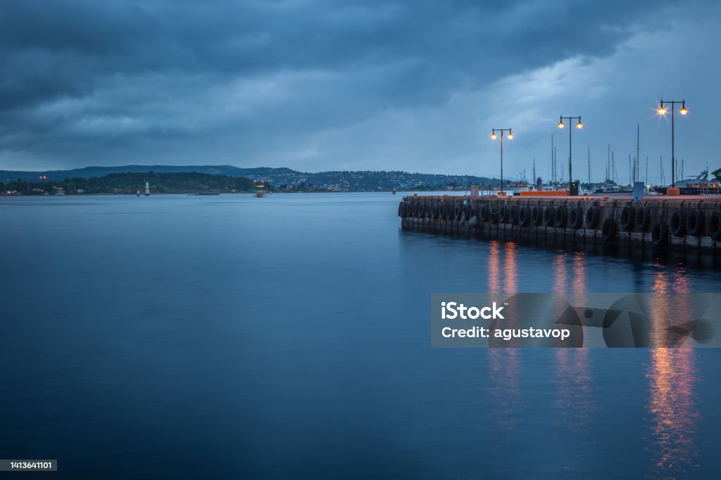 Oslofjord at evening with dramatic sky and pier, Oslo, Norway Oslofjord at evening with dramatic sky and pier, Oslo, Norway, Scandinavia Blurred Motion Stock Photo