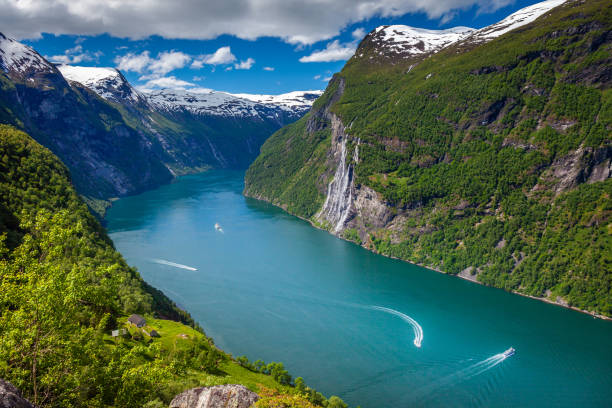 Ferry and boats crossing Geirangerfjord Seven Sisters Waterfalls, Norway Geiranger fjord and Seven Sisters Waterfalls in More og Romsdal, Norway, Northern Europe more og romsdal county stock pictures, royalty-free photos & images