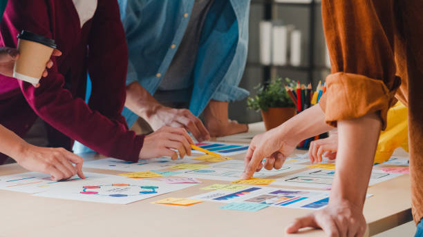 hombres y mujeres de negocios asiáticos que se reúnen para intercambiar ideas sobre la aplicación creativa de planificación de diseño web y el desarrollo de diseño de plantillas para proyectos de teléfonos móviles que trabajan juntos en la oficina. - planning adhesive note business office fotografías e imágenes de stock