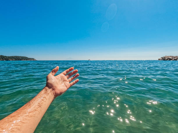 Young man swimming in the sea. Showing off the sea view. His POV.