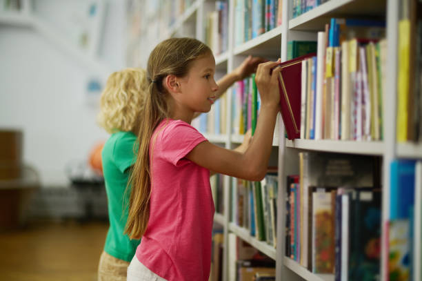 istock Two children selecting educational literature for reading 1413644363