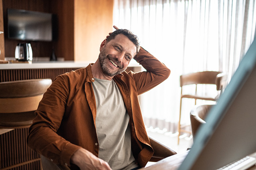 Mature man stretching while watching tutorial in the computer at home