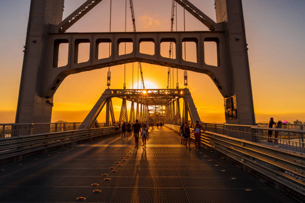 May 1, 2022. Florianopolis, Brazil. Hercilio luz cable bridge with walking people and sunset sky in Florianopolis, Brazil May 1, 2022. Florianopolis, Brazil. Hercilio luz cable bridge with walking people and sunset sky in Florianopolis, Brazil florianópolis stock pictures, royalty-free photos & images