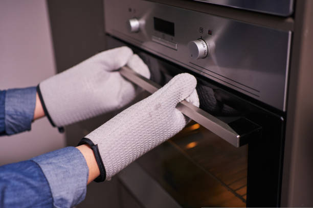 istock female hands in mittens open the oven 1413648262