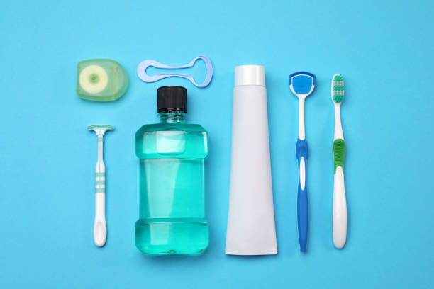 composition de pose plate avec des nettoyants pour la langue et des produits de soins dentaires sur fond bleu clair - toothbrush plastic multi colored hygiene photos et images de collection