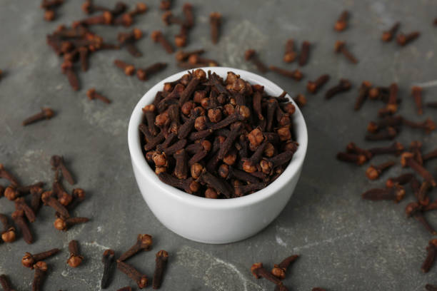 istock Ceramic bowl and aromatic dry cloves on grey table 1413649634
