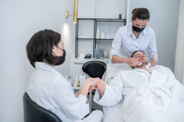 istock Young man having hand massage and face procedures in the salon 1413651156