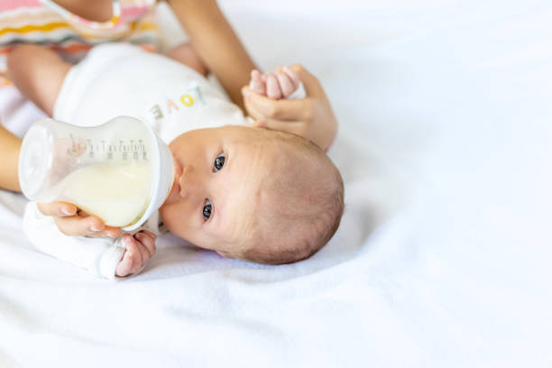 istock Midsection Of Mother Feeding Baby 1413651568