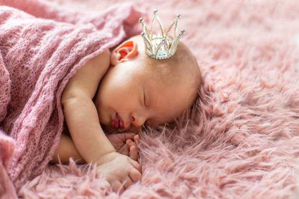 istock Baby Girl Sleeping On Bed Wearing Crown 1413651687
