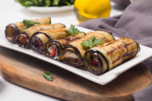 Baked grilled eggplant rolls with cottage cheese, tomatoes and sour cream. Georgian cuisine.