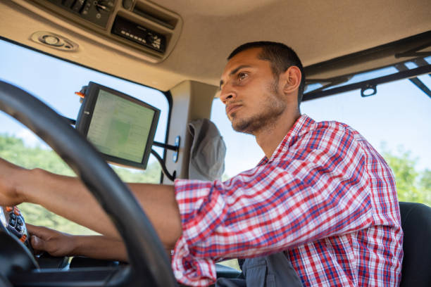 istock Cheerful tractor driver in the cab of his tractor 1413652237