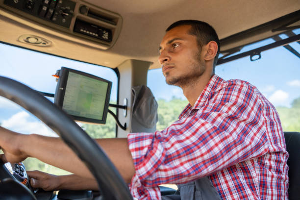 istock Cheerful tractor driver in the cab of his tractor 1413652252