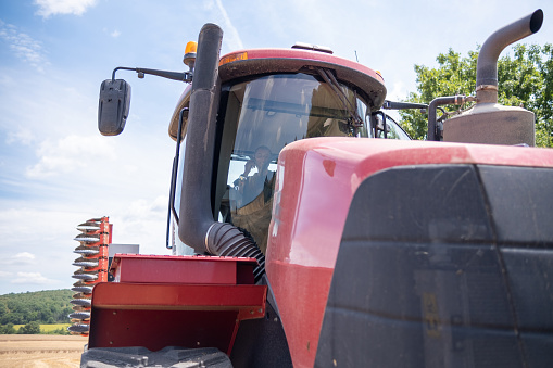 Front view of a tractor with a tractor driver in it.