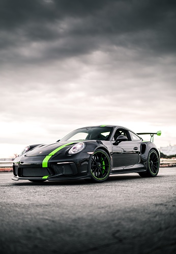 Seattle, WA, USA\nJuly 20, 2022\nBlack Porsche 911 GT3 with a green stripe parked showing the drivers side of the car