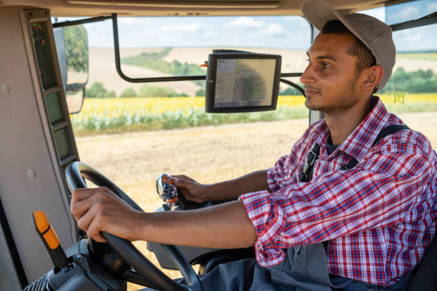 istock Cheerful tractor driver in the cab of his tractor 1413653044