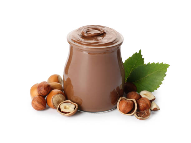 istock Glass jar with tasty chocolate hazelnut spread and nuts on white background 1413653546