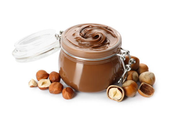istock Glass jar with tasty chocolate hazelnut spread and nuts on white background 1413653604