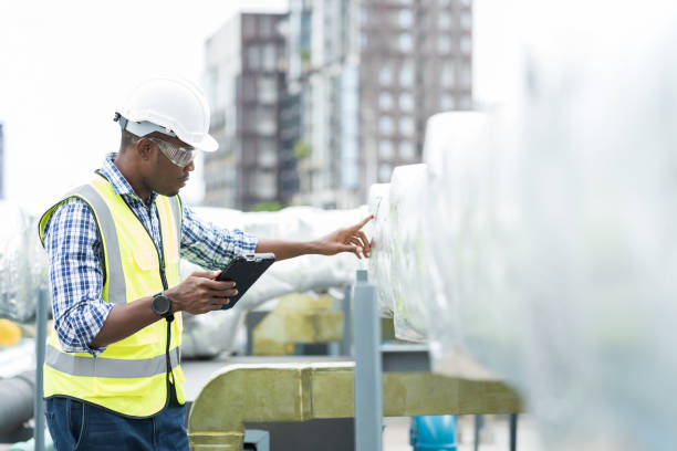 istock Male engineer or male technician work with digital tablet at construction site area. African American male engineer worker check or maintenance pipe system for ventilation and air conditioning 1413654390
