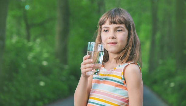 istock Girl Holding Water In Drinking Glass 1413654550