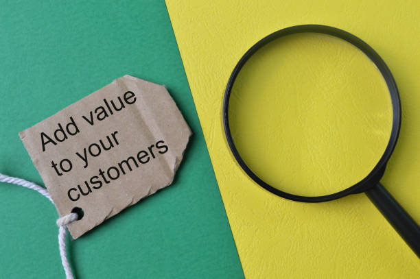 istock Magnifying glass and label tag written with ADD VALUE TO YOUR CUSTOMER 1413656873