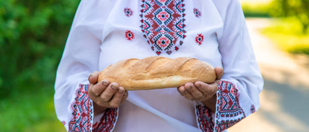 istock Midsection Of Woman Holding Bread 1413659305