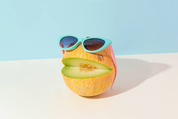 istock Abstract creative summer fruit scene made of cut melon with sunglasses on isolated pastel blue and beige background. Sun and shadow. The idea of happy emoticon. Ocean beach party or vacation concept. 1413661299