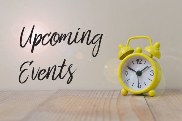 istock Yellow clock on wooden table with text UPCOMING EVENTS 1413662058