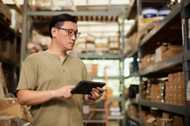 istock Warehouse male worker using digital ipad for work in the warehouse near shelf pallet of products or parcel goods. 1413666144