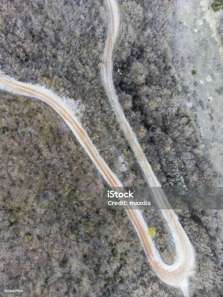 Top-down view of an hairpin bend in the middle of a forest Top-down view of an hairpin bend in the middle of a forest. Above Stock Photo