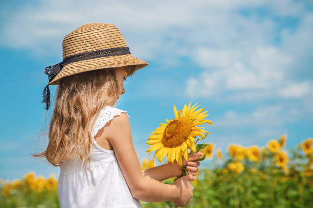 istock Woman Holding Yellow Flower 1413668975