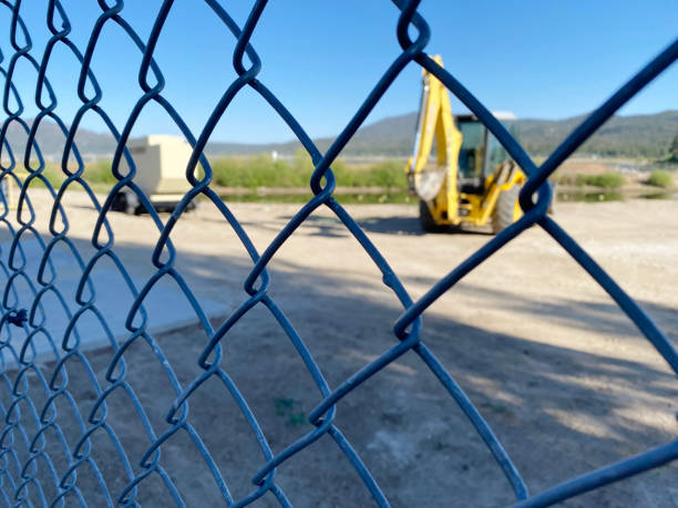istock construction site security fence chain link fencing barrier mesh workers machinery machines blur building structure 1413670717