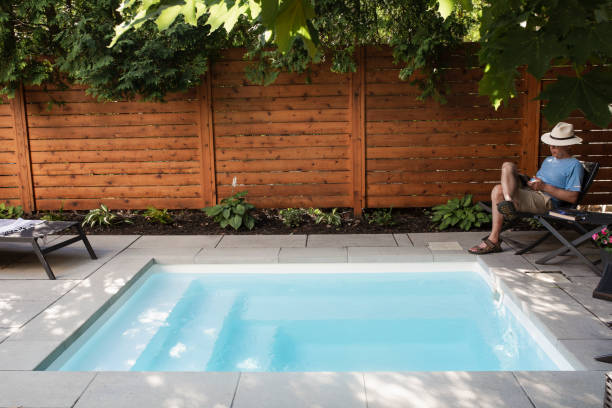 istock A man reading in his back yard by the pool 1413672239