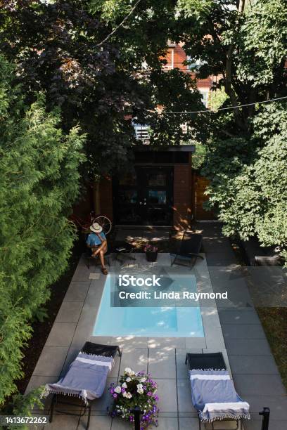 A Man Reading In His Back Yard By The Pool Stock Photo - Download Image Now - Yard - Grounds, Aerial View, Domestic Life