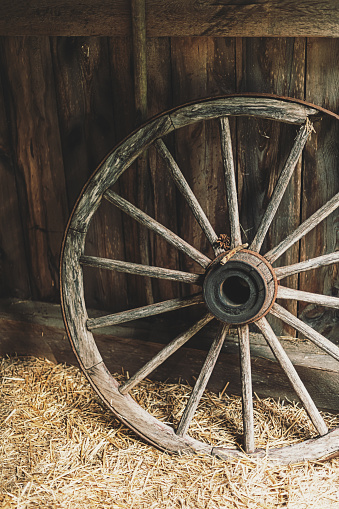 An antique wagon wheel in a barn.