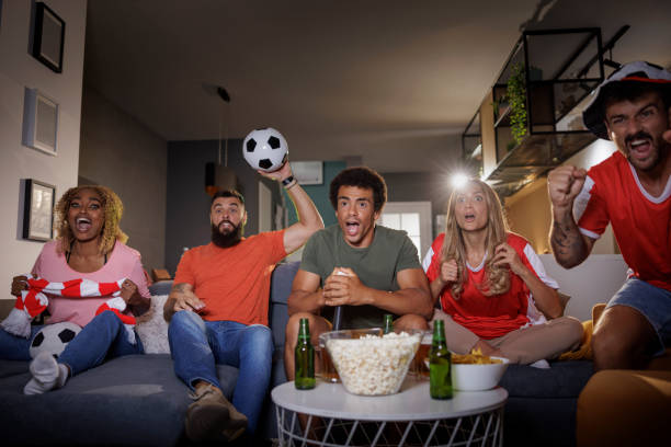 istock People cheering while watching football on TV 1413675142