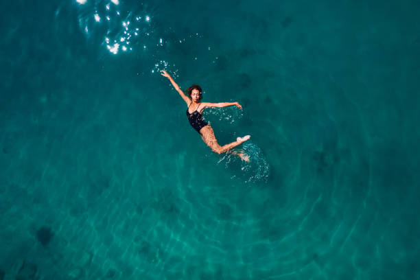 istock Aerial View Young Woman is Floating on Turquoise Waters 1413675863