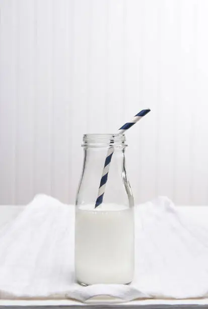 Closeup of a bottle of milk with a drinking straw.