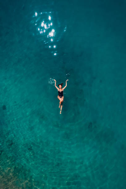 istock Aerial View Young Woman is Floating on Turquoise Waters 1413676152