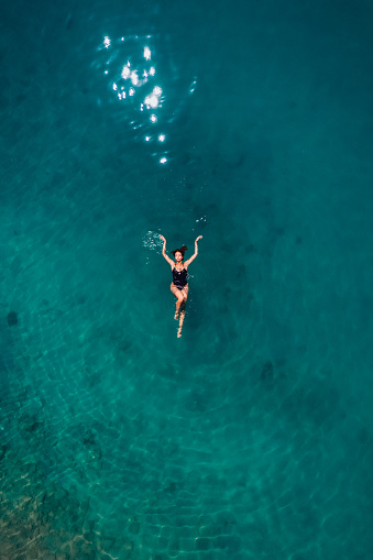 Aerial View Young Woman is Floating on Turquoise Waters