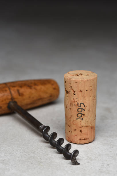 istock Dated Wine Cork with Antique Cork Screw on a gray light to dark background 1413676243