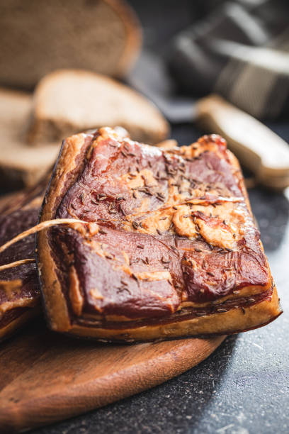 istock Whole smoked bacon on cutting board. 1413676259