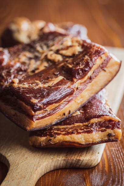 istock Whole smoked bacon on cutting board. 1413676411